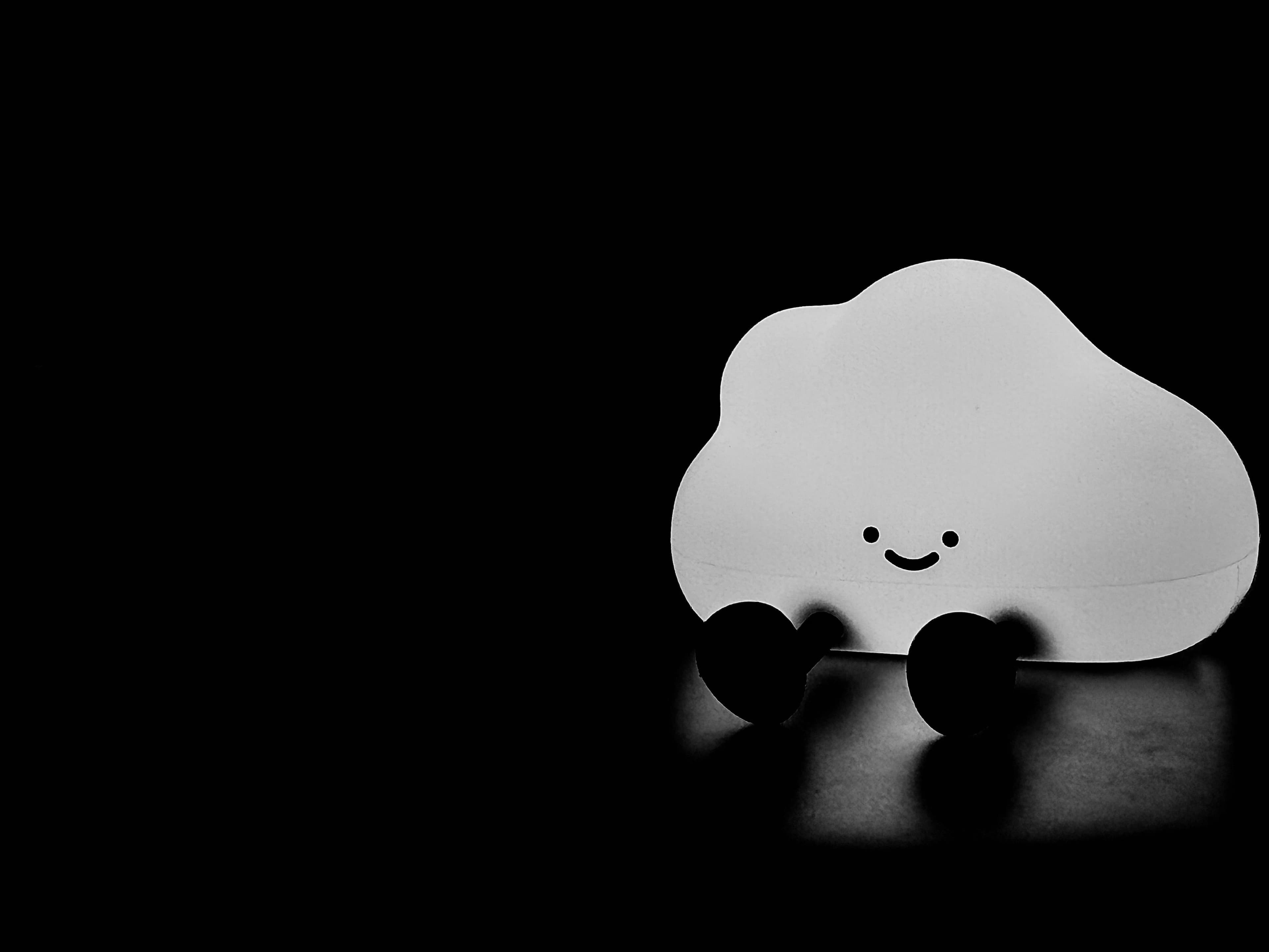 Smiling cloud-shaped night light glowing softly in a dark room
